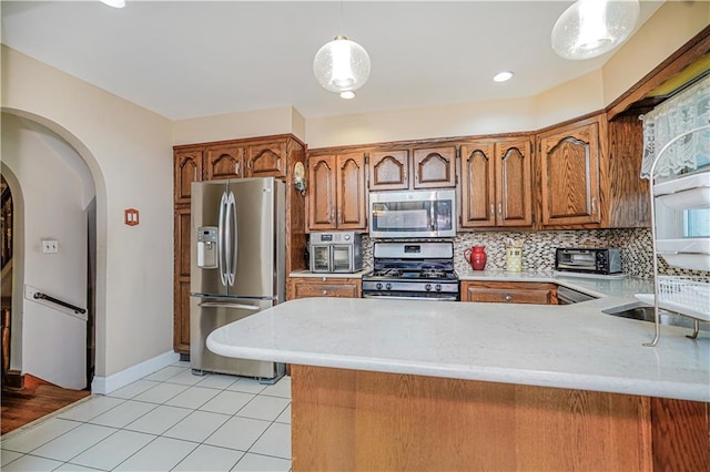 1413 81st St, Brooklyn, NY 11228 - kitchen with stainless steel appliances, arched walkways, brown cabinetry, light tile patterned floors, and recessed lighting