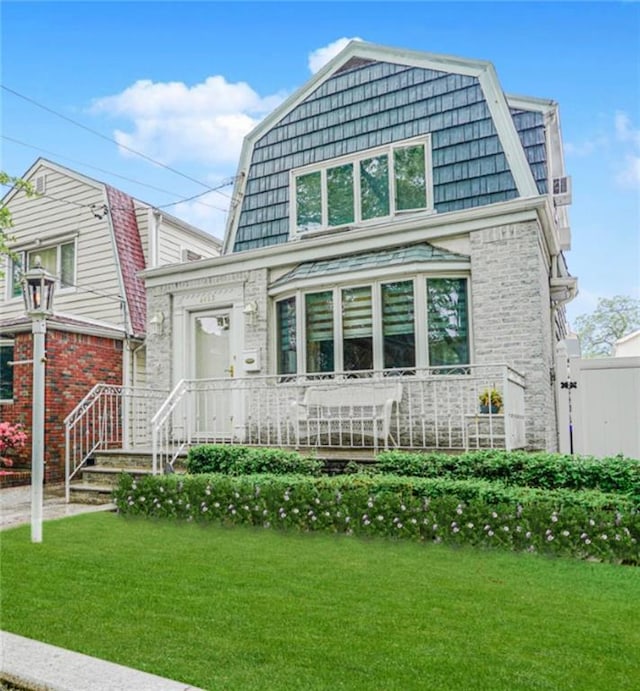 1413 81st St, Brooklyn, NY 11228 - view of front of house with a gambrel roof, a front yard, and brick siding