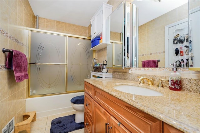 131 Stonegate Dr Unit 1, Staten Island, NY 10304 - full bath with tile walls, vanity, tile patterned flooring, toilet, and bath / shower combo with glass door
