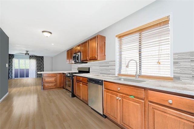 131 Stonegate Dr Unit 1, Staten Island, NY 10304 - kitchen with stainless steel appliances, a sink, a peninsula, and brown cabinetry