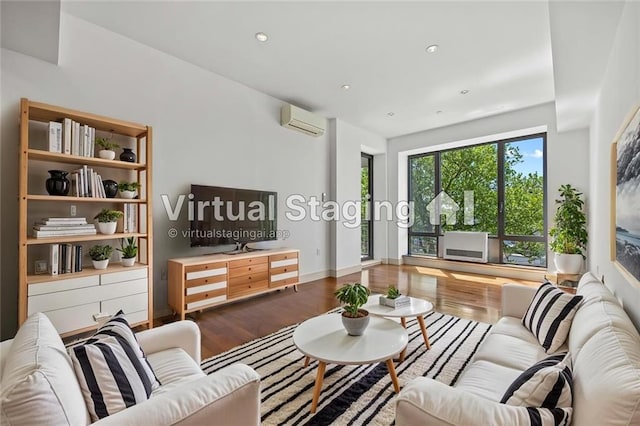 living room with a wall unit AC, wood finished floors, recessed lighting, and baseboards