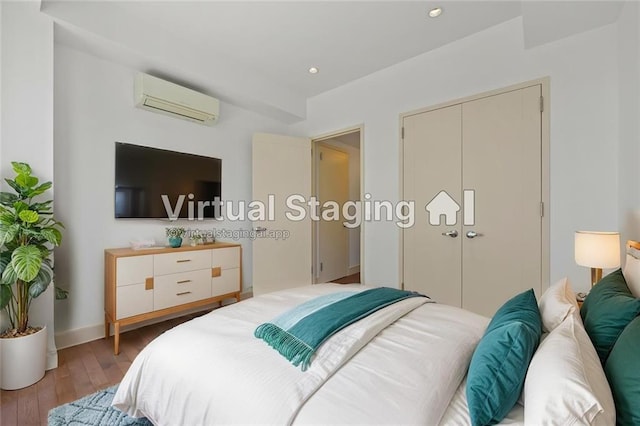 bedroom with an AC wall unit, light wood finished floors, recessed lighting, and a closet