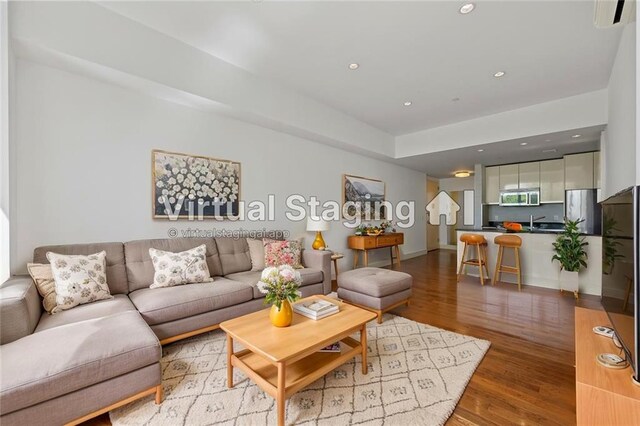 living room with light wood-style floors, recessed lighting, and baseboards
