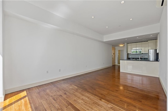 unfurnished living room with light wood-type flooring, baseboards, and recessed lighting