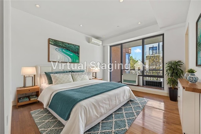 bedroom featuring access to exterior, wood-type flooring, an AC wall unit, and recessed lighting