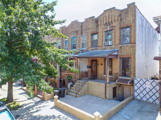 view of property with brick siding and cooling unit