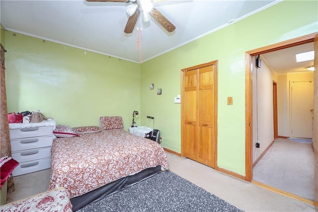 bedroom featuring ornamental molding, light colored carpet, baseboards, and ceiling fan