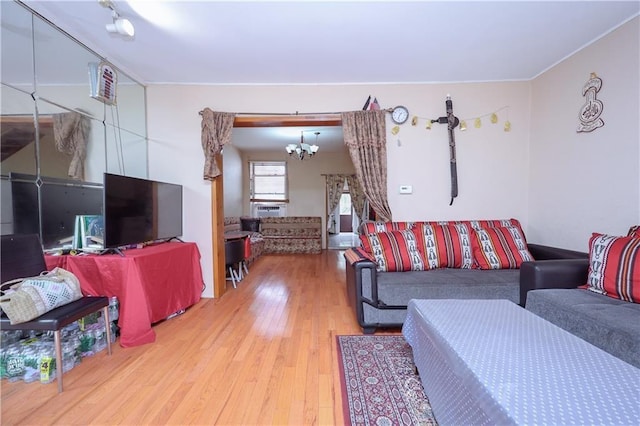 living area with light wood-style floors, a chandelier, and crown molding