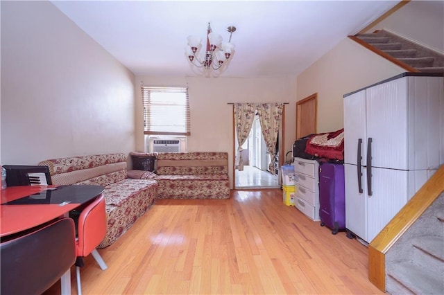 living area featuring a chandelier, light wood-style flooring, stairs, and cooling unit