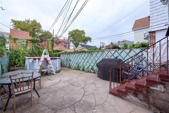 view of patio with outdoor dining space, fence, area for grilling, and stairs