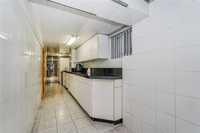 1519 71st St, Brooklyn, NY 11228 - kitchen with dark countertops, tile walls, white cabinets, and light tile patterned floors
