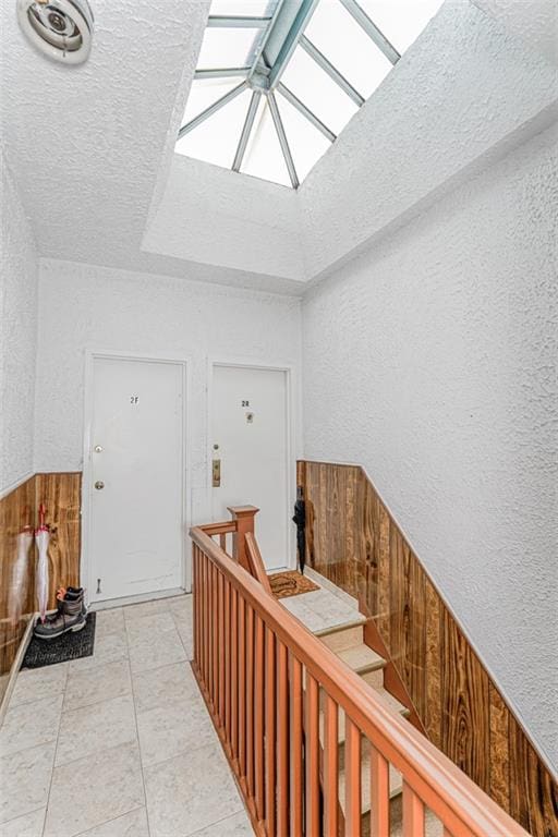 1519 71st St, Brooklyn, NY 11228 - staircase featuring a textured wall, a skylight, and wood walls