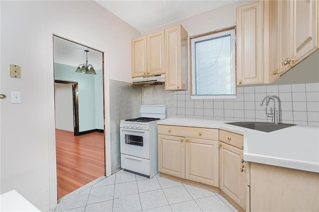 1519 71st St, Brooklyn, NY 11228 - kitchen featuring white range with gas cooktop, a sink, under cabinet range hood, tasteful backsplash, and light countertops