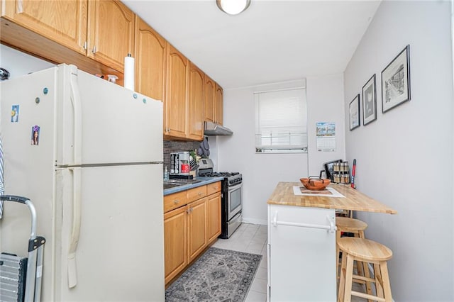 1519 71st St, Brooklyn, NY 11228 - kitchen featuring freestanding refrigerator, stainless steel range with gas stovetop, under cabinet range hood, a breakfast bar, and backsplash