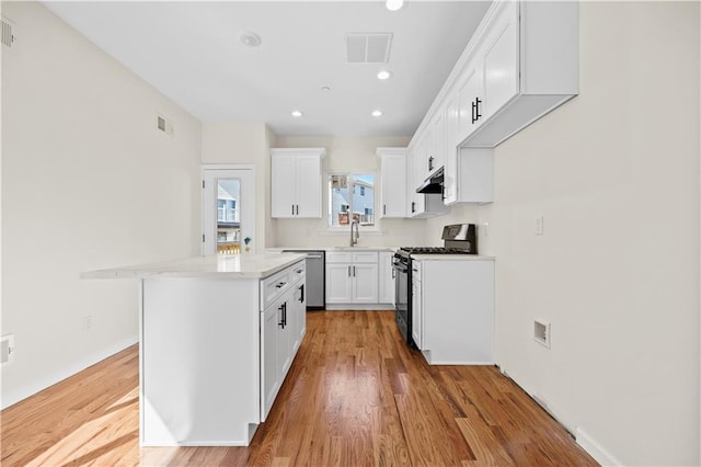 91 Robin Rd, Staten Island, NY 10305 - kitchen featuring range with gas cooktop, stainless steel dishwasher, under cabinet range hood, a center island, and white cabinets