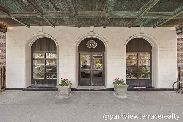 property entrance with brick siding and covered porch
