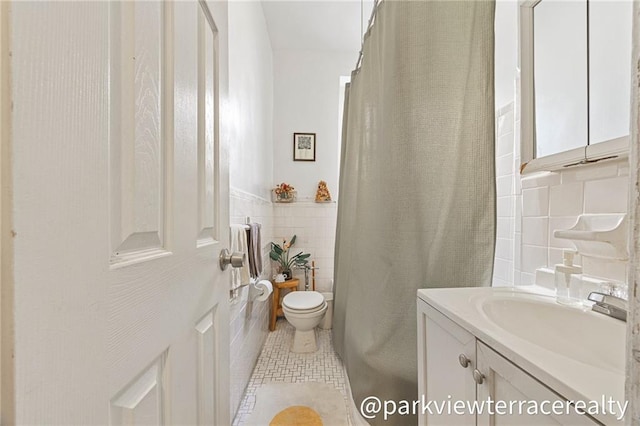 full bathroom featuring tile walls, toilet, tile patterned floors, and vanity