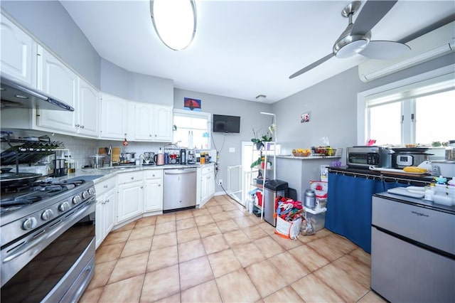 kitchen with stainless steel appliances, a ceiling fan, white cabinets, light countertops, and backsplash