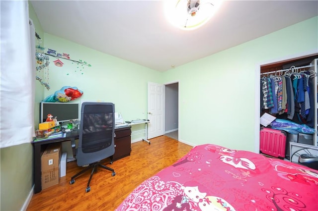 bedroom featuring wood finished floors, a closet, and baseboards