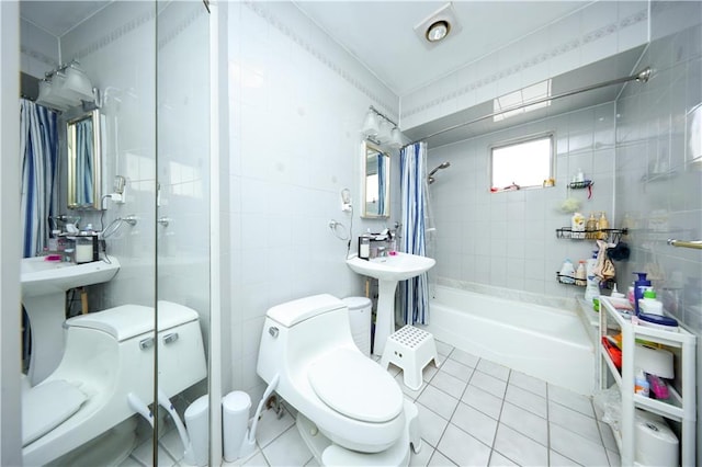 full bath featuring tile walls, toilet, tile patterned floors,  shower combination, and a sink