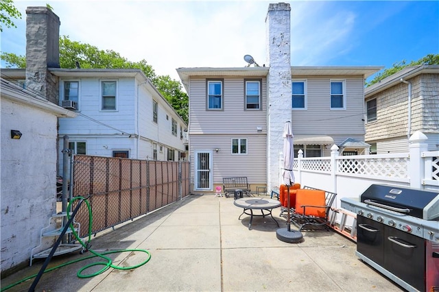 back of house with a patio area and a chimney