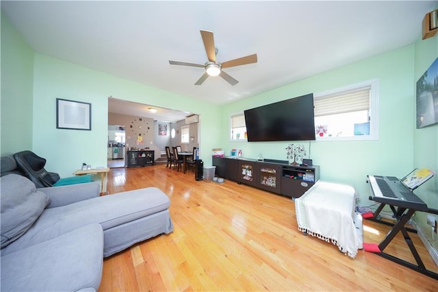 living area featuring plenty of natural light, a ceiling fan, and wood finished floors