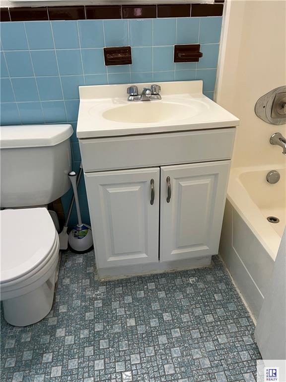 bathroom with vanity, toilet, and bathtub / shower combination