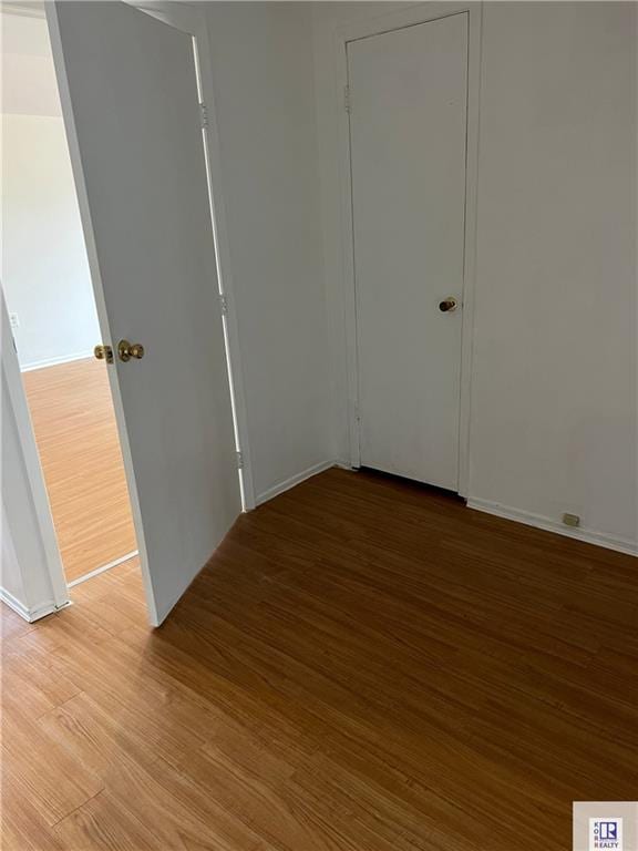 empty room featuring light wood-type flooring and baseboards