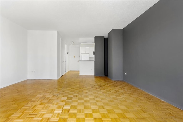 unfurnished living room with baseboards