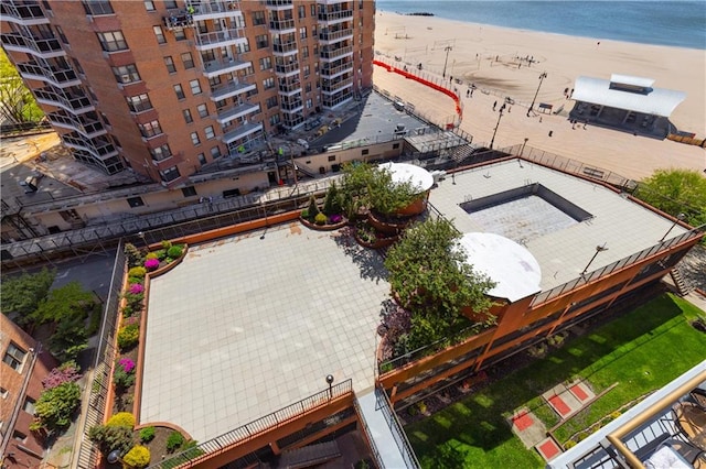 drone / aerial view of waterfront with a beach and apartment complex