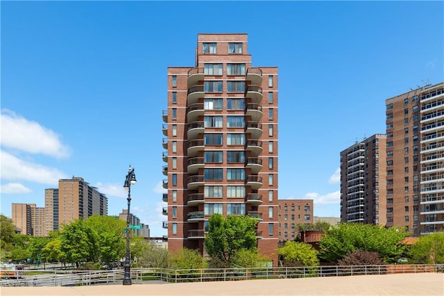 view of building exterior with fence and a city view