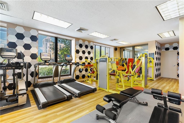 exercise room with wood finished floors and a textured ceiling
