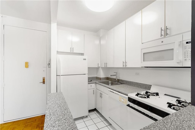 kitchen with white appliances, a sink, white cabinets, and light countertops