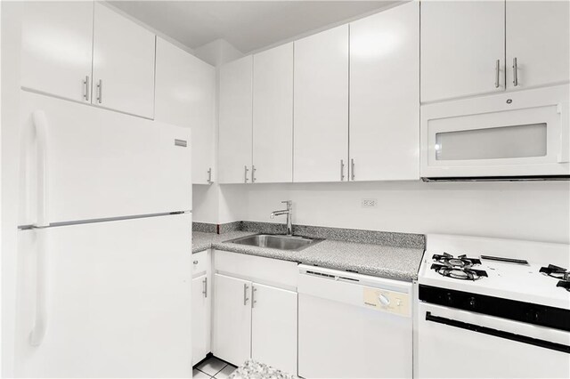 kitchen with white appliances, a sink, light countertops, and white cabinets