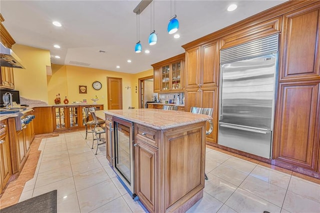 1401 74th St, Brooklyn, NY 11228 - kitchen with stainless steel appliances, brown cabinetry, beverage cooler, light stone counters, and recessed lighting
