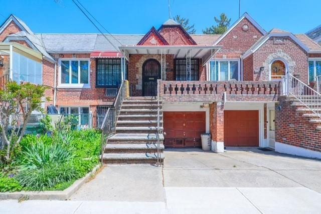 2327 E 16th St, Brooklyn, NY 11229 - view of front facade featuring brick siding, stairway, driveway, and an attached garage