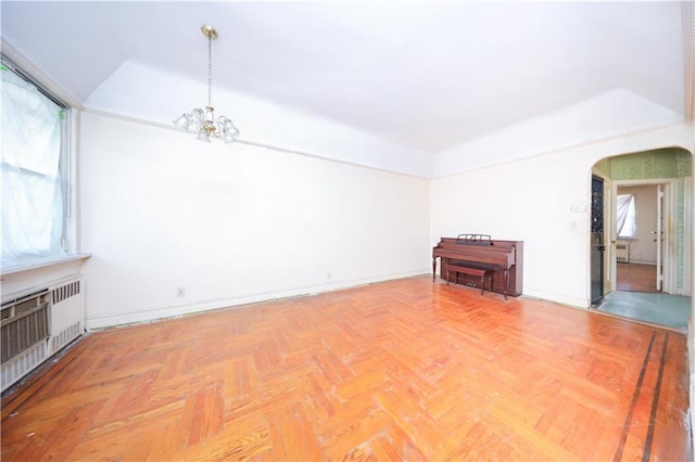 2327 E 16th St, Brooklyn, NY 11229 - unfurnished living room featuring a chandelier, arched walkways, radiator heating unit, and baseboards
