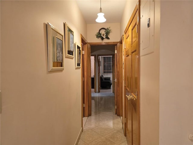 hall with arched walkways and light tile patterned flooring