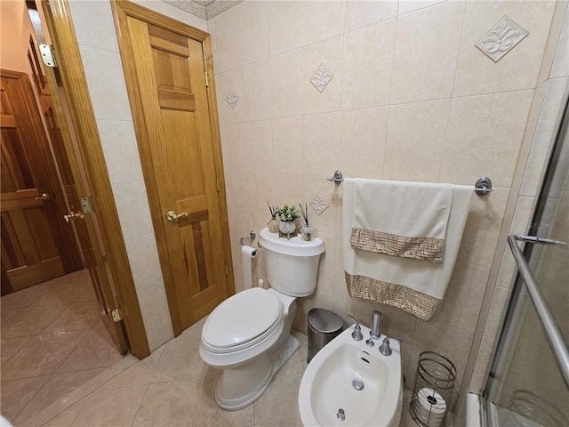 bathroom featuring tile walls, a stall shower, toilet, a bidet, and tile patterned flooring