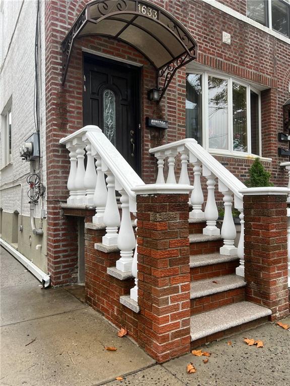 view of exterior entry featuring brick siding