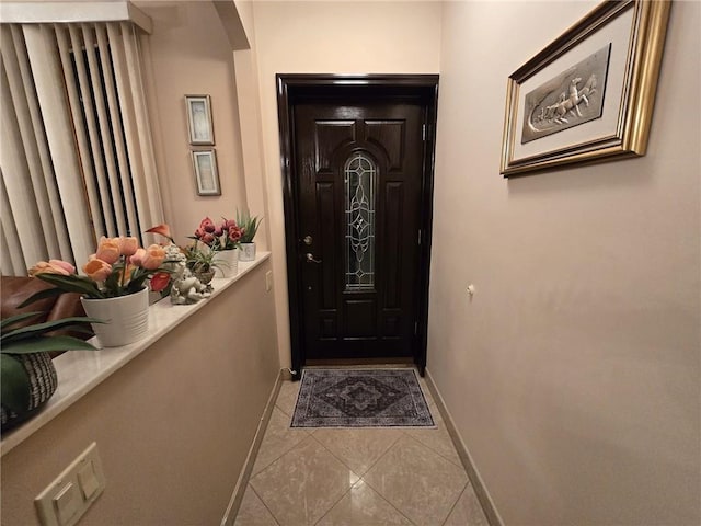 entryway with baseboards and tile patterned flooring