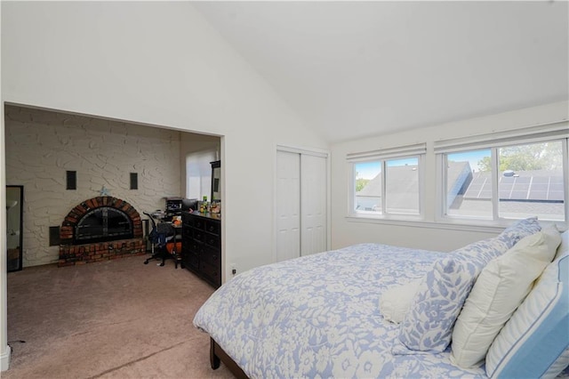 carpeted bedroom featuring high vaulted ceiling, a fireplace, and a closet