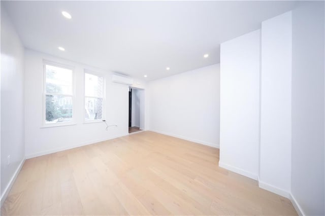 1238 77th St, Brooklyn, NY 11228 - empty room featuring light wood finished floors, a wall unit AC, and recessed lighting