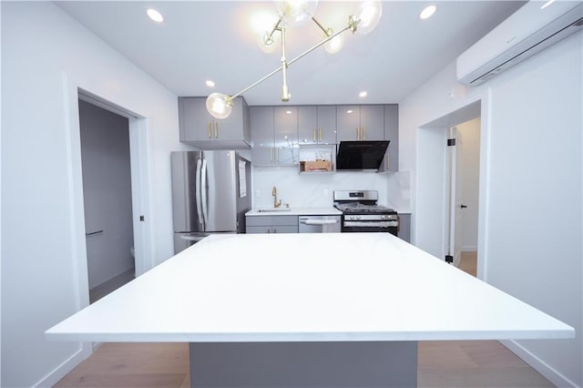 1238 77th St, Brooklyn, NY 11228 - kitchen featuring stainless steel appliances, gray cabinets, a wall unit AC, range hood, and a kitchen island