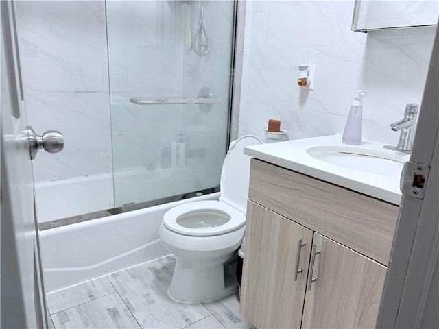 2349 W 12th St, Brooklyn, NY 11223 - full bathroom with tile walls, toilet, vanity, and combined bath / shower with glass door