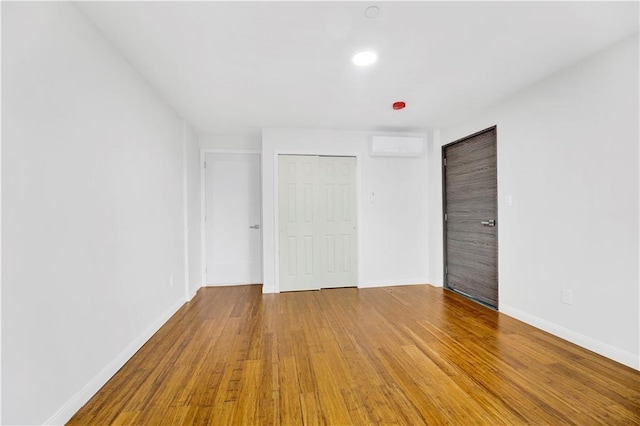 unfurnished bedroom with baseboards, wood finished floors, a closet, and recessed lighting