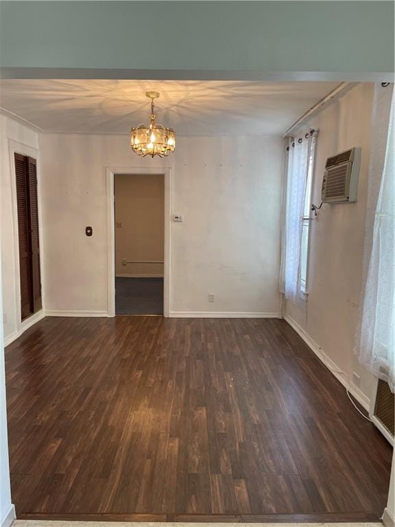 unfurnished dining area featuring a wall mounted air conditioner, dark wood-type flooring, a chandelier, and baseboards