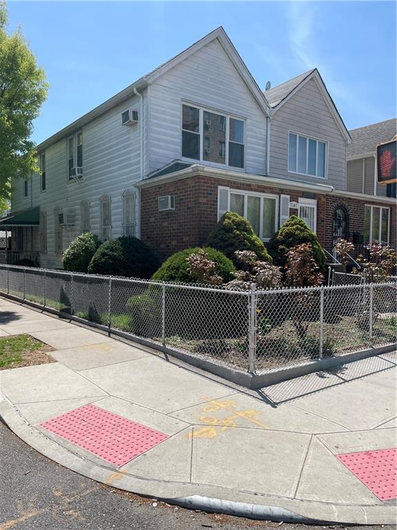 view of front of home featuring brick siding and a wall unit AC
