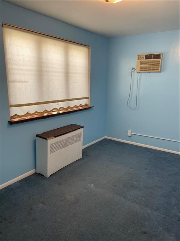 carpeted empty room with radiator, baseboards, and an AC wall unit