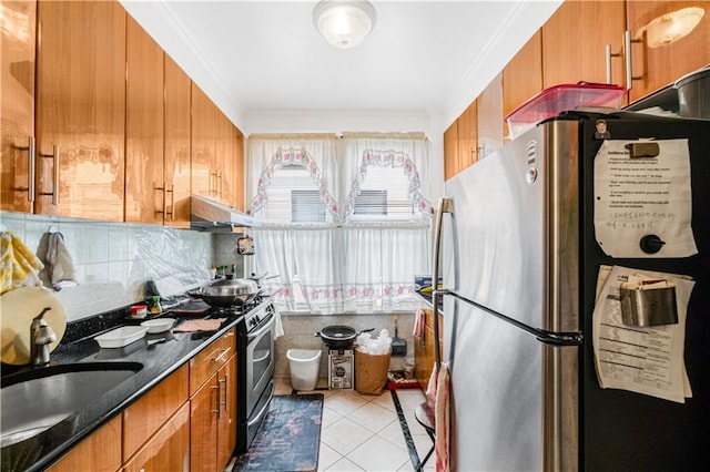 kitchen featuring appliances with stainless steel finishes, brown cabinetry, light tile patterned floors, backsplash, and ornamental molding